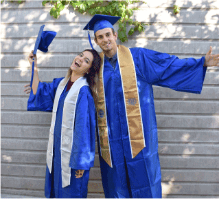 two students pose in graduation robes